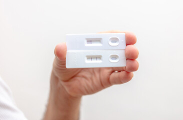 Man hand holding Covid 19 positive and negative result self test.