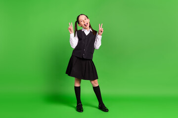 Photo of charming tricky schoolgirl dressed white black uniform smiling showing tongue v-sign...