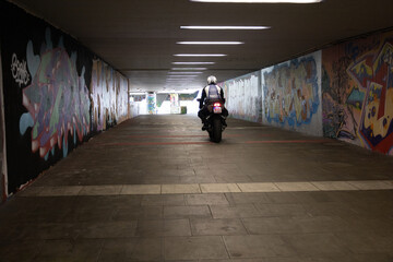 Motorradfahrer in bunten Graffiti Tunnel 