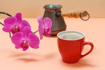 Obraz na płótnie Canvas Red orchid flowers with cup of coffee on a beige background.