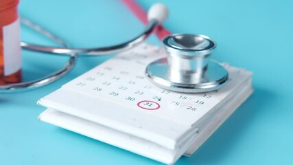 close up of stethoscope on calendar on blue background 