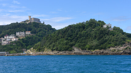 Fototapeta premium San Sebastian, Spain - 2 August 2021: Views of Monte Igueldo from Isla Santa Clara and La Concha Bay