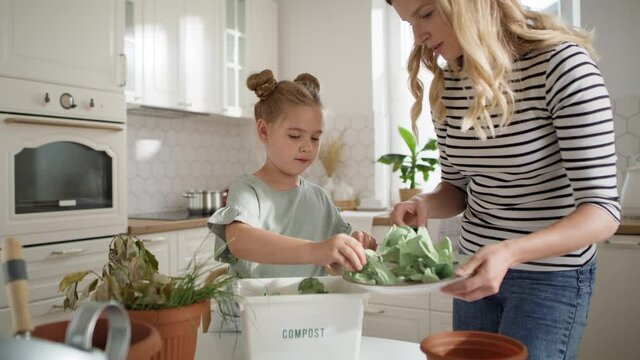 Video of mother and daughter doing compost at home. Shot with RED helium camera in 8K
