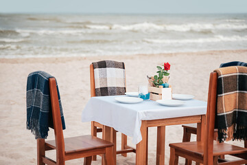 Romantic dinner table on sea shore. Preparing for dinner in restaurant by sea.
