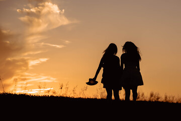 Two female silhouette figures in the afternoon light. Happiness concept
