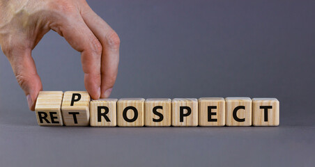 Prospect or retrospect symbol. Businessman turns wooden cubes and changes the word 'retrospect' to 'prospect'. Beautiful grey background. Business and prospect or retrospect concept. Copy space. - obrazy, fototapety, plakaty