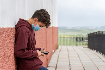Obraz premium boy playing video games on his smart phone after school