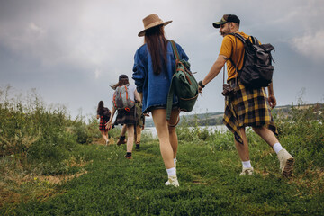 Young man and woman, family couple walking, strolling together outskirts of city, at summer forest. Active lifestyle, travel, eco, relationship concept