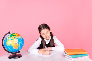 Photo of young school girl sit desk classroom write notes lesson study education isolated over pink color background