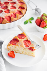 Strawberry vanilla sponge cake or pie on a white wooden background with fresh strawberries. Summer dessert. Copy space.