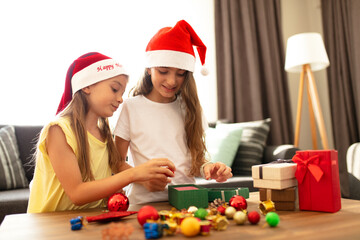 Two sisters preparing Christmas gifts at home. christmas gift concept.