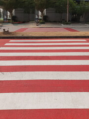 The top view of the red and white zebra is a symbol of a safe road crossing. On the concrete road paint on a concrete road to mark traffic

