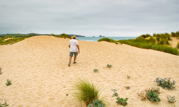Hombre caminando por las dunas de arena de Liencres, en la costa de Cantabria, Espa&ntilde;a