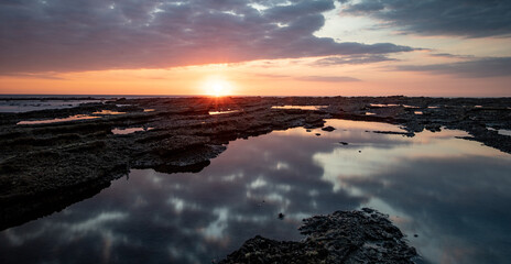 Beautiful reflective sunset at tide pools in Nosara, Guanacaste Costa rica.