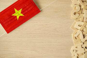 Vietnam flag on hygienic mask. Rustic background with empty space.
