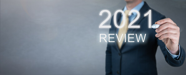 businessman writes 2021 review words. last year review in business. economic indicators, overcoming...