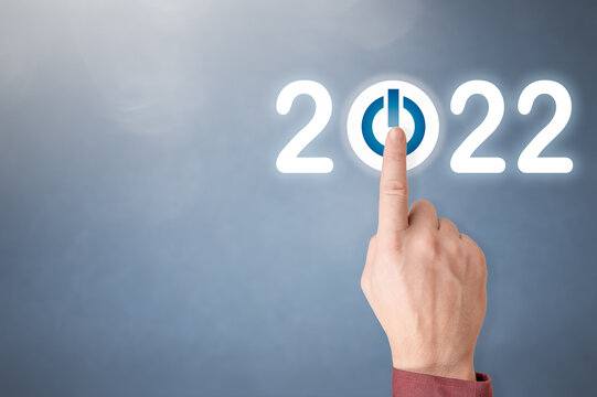 Finger pressing blue start 2022 button on virtual interface on gray background with copy space for text. Businessman pressing 2022 start up business. Press the start button.. Concept of new year