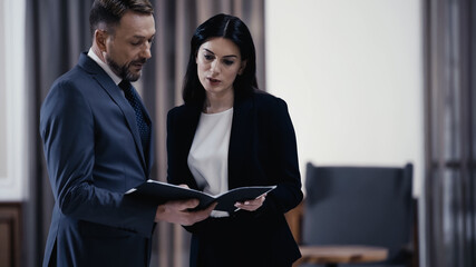 Business partners looking at documents in lobby of restaurant