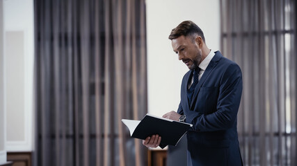 bearded businessman looking at documents in paper folder