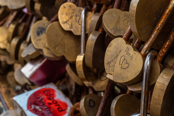 Many padlocks in the shape of a heart glued to the gate as a symbol of the love of a couple in the city of Paris