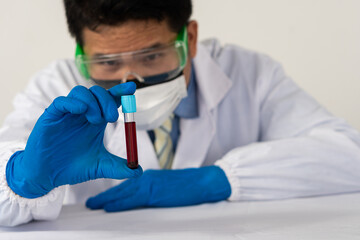 close-up of microbiologist or doctor holding blood test tubes in medical science laboratory