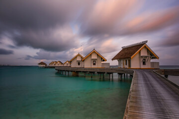 Island in ocean, overwater villas at the time sunset. Crossroads Maldives, saii lagoon. Long exposure picture taken in june 2021