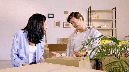 happy couple looking at each other while packing box