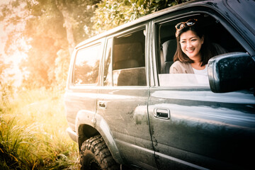 Asian Woman driveing a car on road trip.
