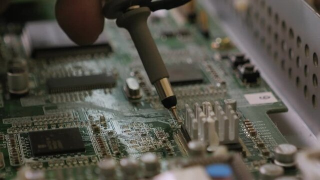 Repair of computer motherboard, soldering the microchip with a soldering dryer.