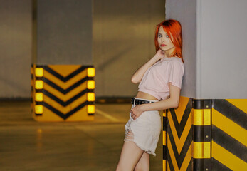 Beautiful young woman near a wall in parking