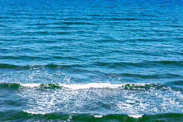 Blue sea water background.Blue sea surface with waves.waves in the ocean.Deep blue water waves.Foam splash.Copy space.