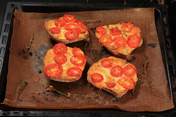 Tomato Mozzarella Toast on metal pan. Sandwich toasts with tomatoes, mozzarella and basil leaves