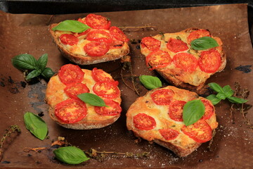 Tomato Mozzarella Toast on metal pan. Sandwich toasts with tomatoes, mozzarella and basil leaves