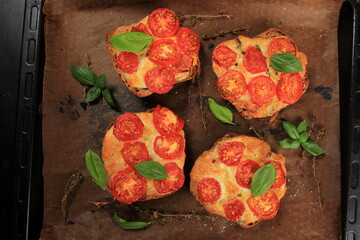 Tomato Mozzarella Toast on metal pan. Sandwich toasts with tomatoes, mozzarella and basil leaves
