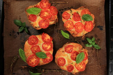 Tomato Mozzarella Toast on metal pan. Sandwich toasts with tomatoes, mozzarella and basil leaves