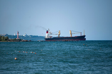 A cargo ship enters the sea from the port.