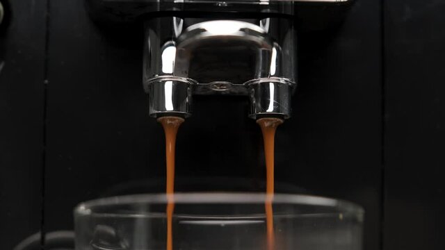 Close-up of the slow movement of Espresso pouring from the coffee machine.