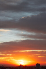 Sunrise skyline with red color fire on a cloudy winter day on a city. Space for text.