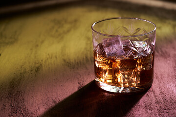 glass of whiskey in bar with colored lights