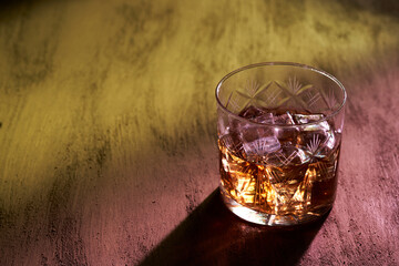 glass of whiskey in bar with colored lights