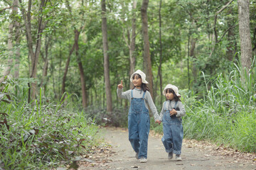 Children are heading to the family campsite in the forest Walk along the tourist route. Camping road. Family travel vacation concept.