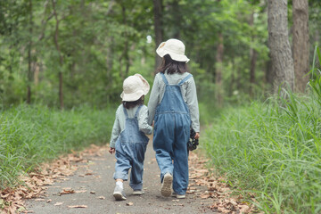 Children are heading to the family campsite in the forest Walk along the tourist route. Camping road. Family travel vacation concept.