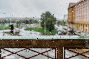 Rain drops during rain in rainy day.View outside window, glass with blurred background.Water droplet flowing down the surface.Wet glass,bad weather,staying at home concept.Moody and rainy day