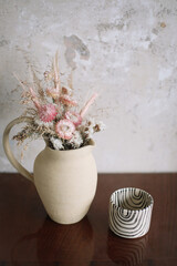 still life with dry flowers in a ceramic vase and a cup. Home decor, interior details