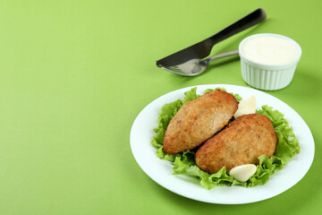 Concept of tasty food with cutlets on green background