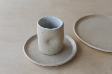 ceramic cup and plates on a wooden table top view. minimalist set of handmade ceramic tableware and pottery