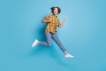 Fototapeta na wymiar Photo of champion crazy lady jump scream raise fists wear plaid shirt jeans shoes isolated blue color background