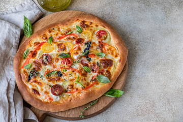 Pinsa with vegetables and cheese, concrete background. Traditional rome pizza. Top view.