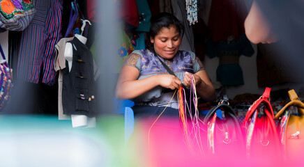 woman who uses her hands to make traditional fabrics. Mexican mecicana merchant works. - obrazy, fototapety, plakaty