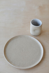 ceramic cup and plates on a wooden table top view. minimalist set of handmade ceramic tableware and pottery